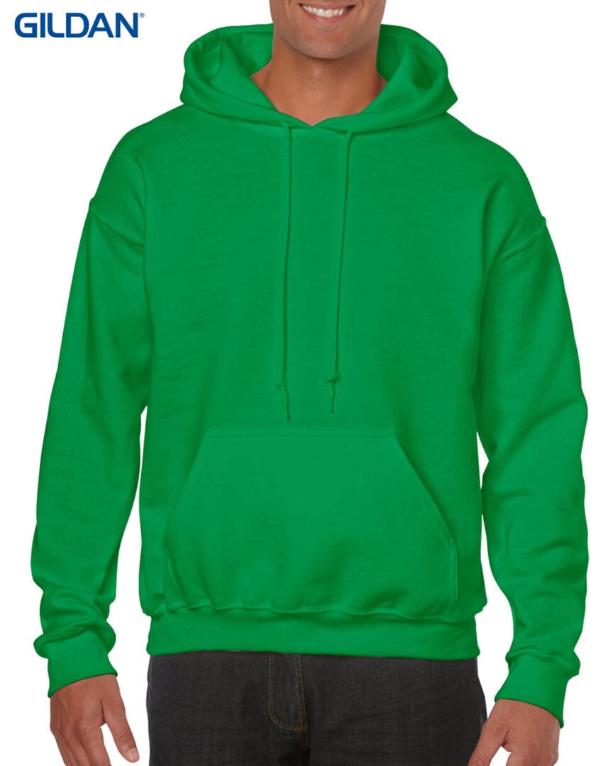 A man wearing a green hoodie with his hands on the hood.