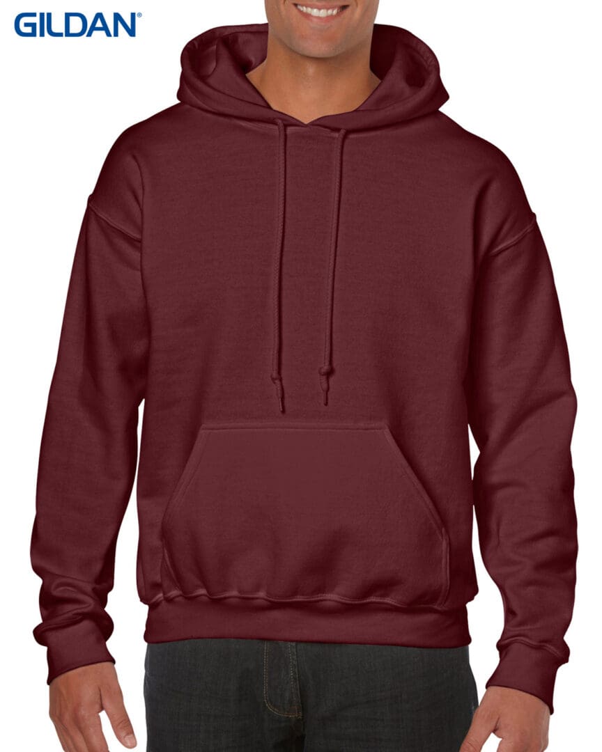 A man wearing a maroon hoodie with his hands on the hood.