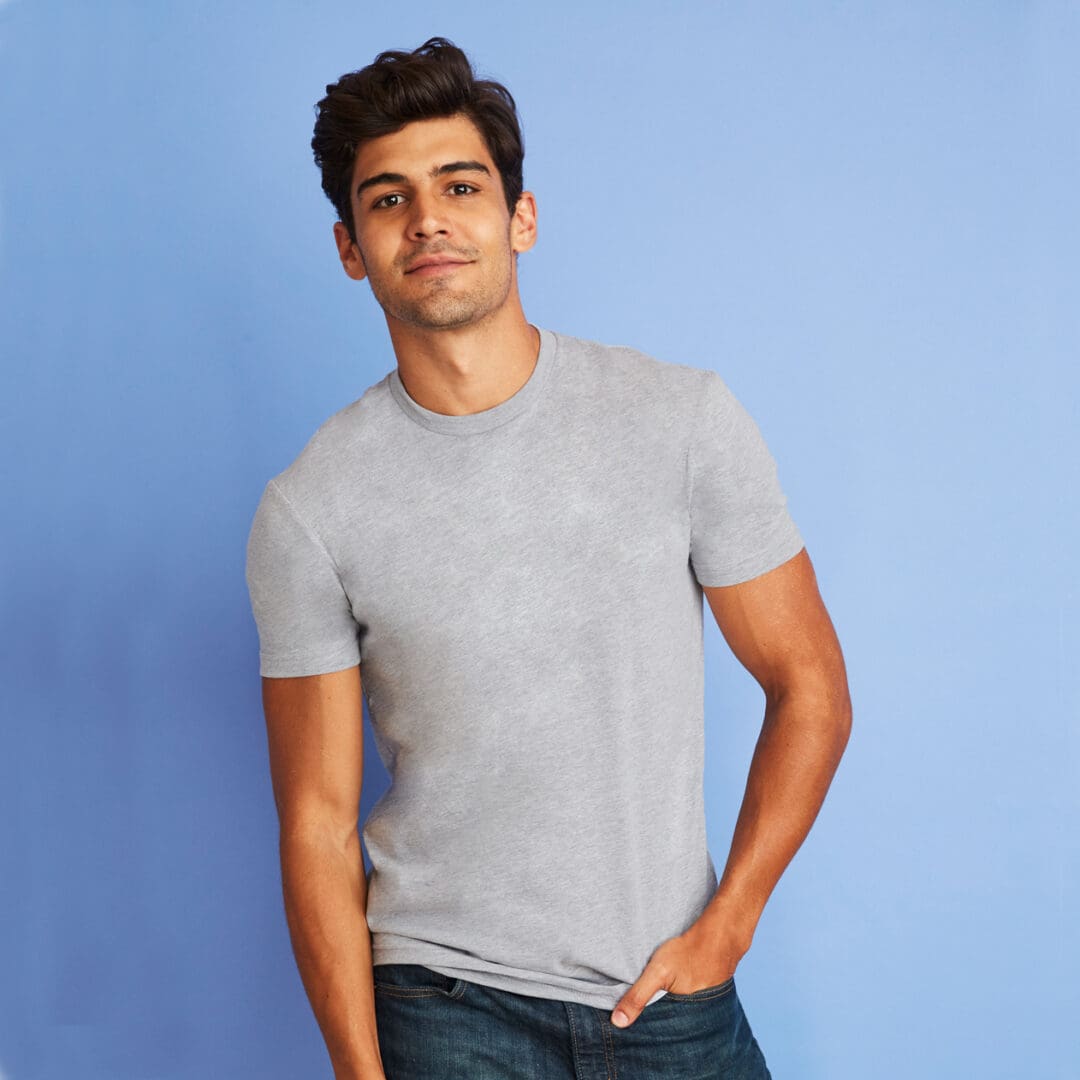 A man in grey shirt and jeans posing for the camera.