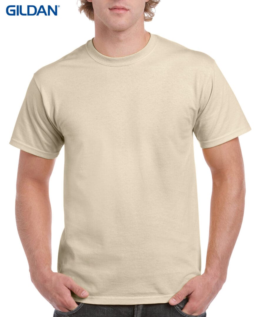 A man wearing a tan t-shirt with no background.